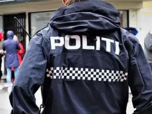 A photo of the back of a man wearing a blue and white politi jacket.